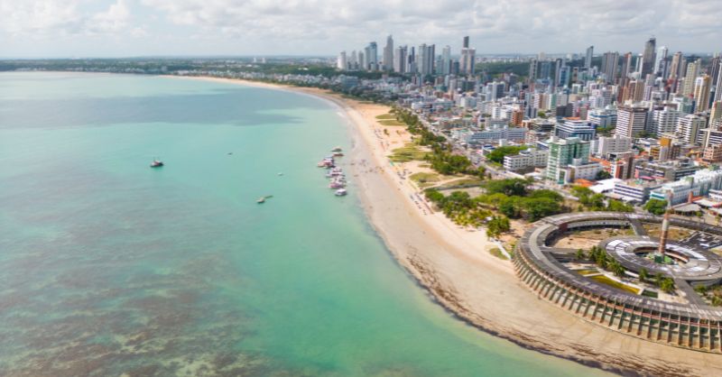 Vista aérea da orla de João Pessoa com os modernos edifícios do Altiplano, ilustrando o ganho real de investir em imóveis em João Pessoa.