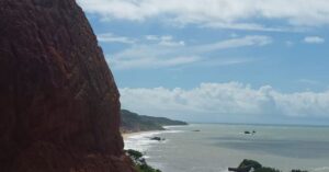 Imóveis abaixo do valor de mercado no Litoral Sul, destacando a paisagem deslumbrante da Praia de Tambaba com suas rochas, mar azul e vegetação preservada.