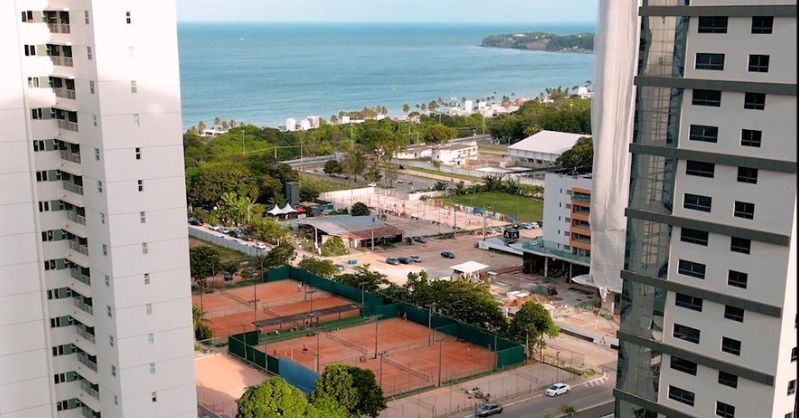 Vista panorâmica e definitiva para a praia a partir da varanda de um lançamento de luxo no Altiplano, ilustrando o ganho real de imóveis vs renda fixa em João Pessoa.